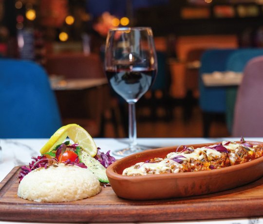 Platter of kebabs, hummus, falafels all laid out in bowls and dishes, shot from above